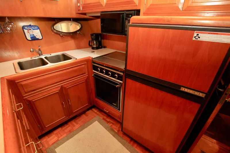 Slide: The Image of 1987 Ocean Alexander 42 yacht kitchen with wood cabinetry, double sink, and appliances. - 45