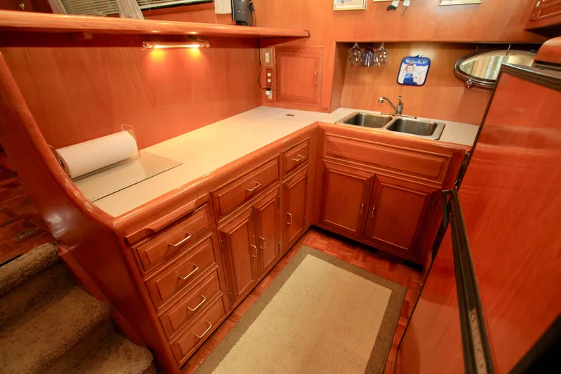 Slide: The Image of 1987 Ocean Alexander 42 yacht kitchen with wooden cabinetry and dual sink. - 46