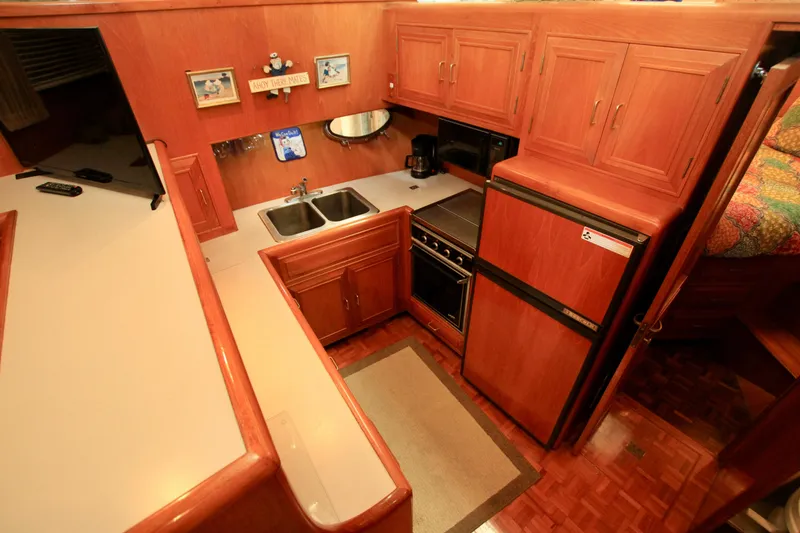 Slide: The Image of 1987 Ocean Alexander 42 yacht kitchen with wood cabinetry, double sink, and appliances. - 47