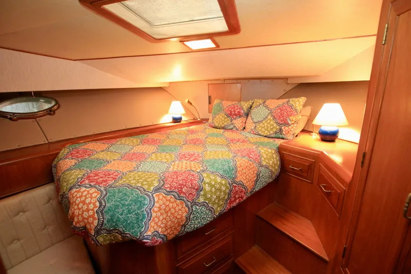 Slide: The Image of Cozy cabin interior of 1987 Ocean Alexander 42 with colorful bedding and warm lighting. - 53