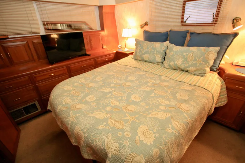 Slide: The Image of Cozy bedroom in 1987 Ocean Alexander 42 yacht with nautical-themed bedding and wooden cabinetry. - 56