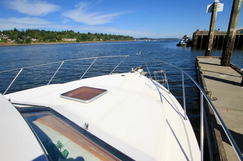 Slide: The Image of 1987 Ocean Alexander 42 yacht docked by a scenic waterfront under clear blue skies. - 6