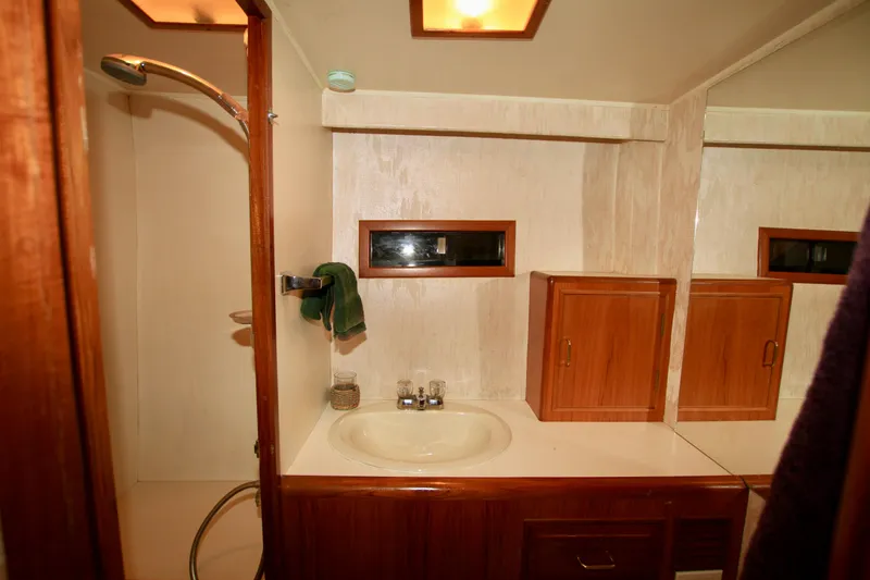 Slide: The Image of 1987 Ocean Alexander 42 yacht bathroom with shower, sink, and wooden cabinets. - 63