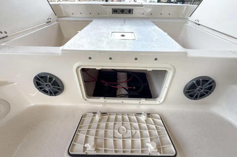 Slide: The Image of 2026 Carolina Skiff 23 LS boat interior with storage compartment and speakers. - 25
