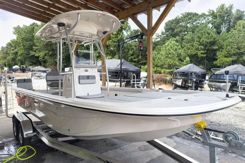 Slide: The Image of 2026 Carolina Skiff 23 LS boat on trailer under wooden shelter, surrounded by trees. - 28