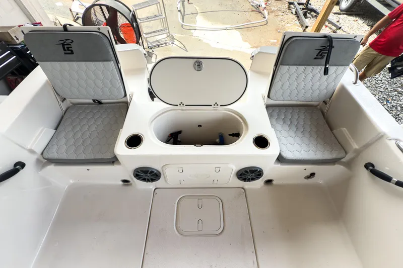 Slide: The Image of 2026 Carolina Skiff 23 LS boat with Suzuki engine displayed indoors. - 6