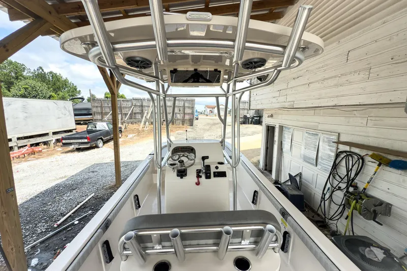 Slide: The Image of 2026 Carolina Skiff 23 LS boat interior with seating and console, parked outdoors. - 9