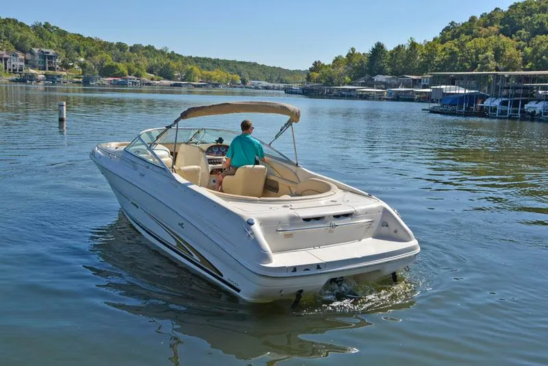 Slide: The Image of 2000 Sea Ray 260 Bow Rider on a calm lake, surrounded by lush greenery. - 11