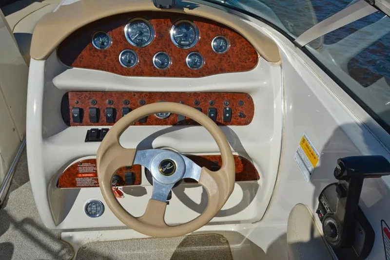 Slide: The Image of Steering console of a 2000 Sea Ray 260 Bow Rider boat with gauges and controls. - 12
