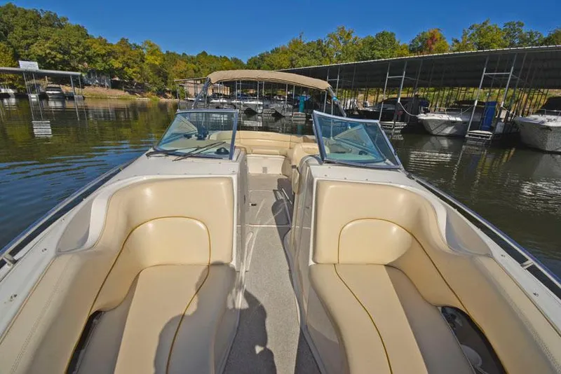 Slide: The Image of 2000 Sea Ray 260 Bow Rider with beige seating, docked at a marina. - 18