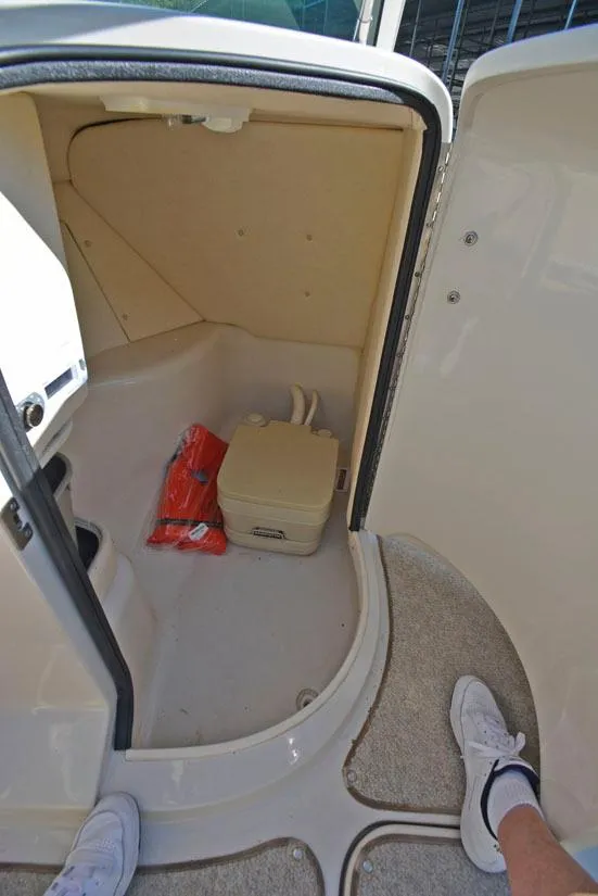 Slide: The Image of 2000 Sea Ray 260 Bow Rider interior storage compartment with portable toilet. - 20