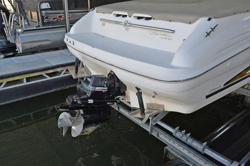 Slide: The Image of 2000 Sea Ray 260 Bow Rider boat docked, rear view showing outboard motor. - 24
