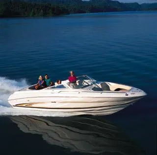 Slide: The Image of 2000 Sea Ray 260 Bow Rider cruising on a serene lake with passengers onboard. - 25