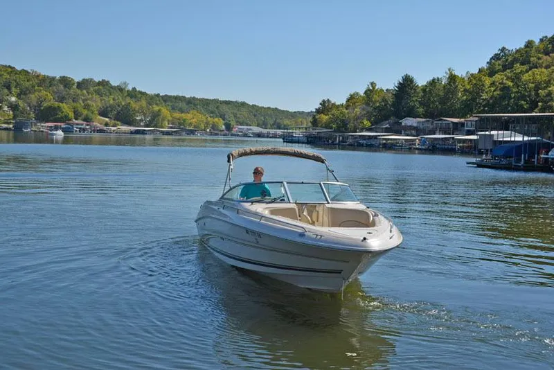 Slide: The Image of 2000 Sea Ray 260 Bow Rider on a serene lake with lush green shoreline. - 3