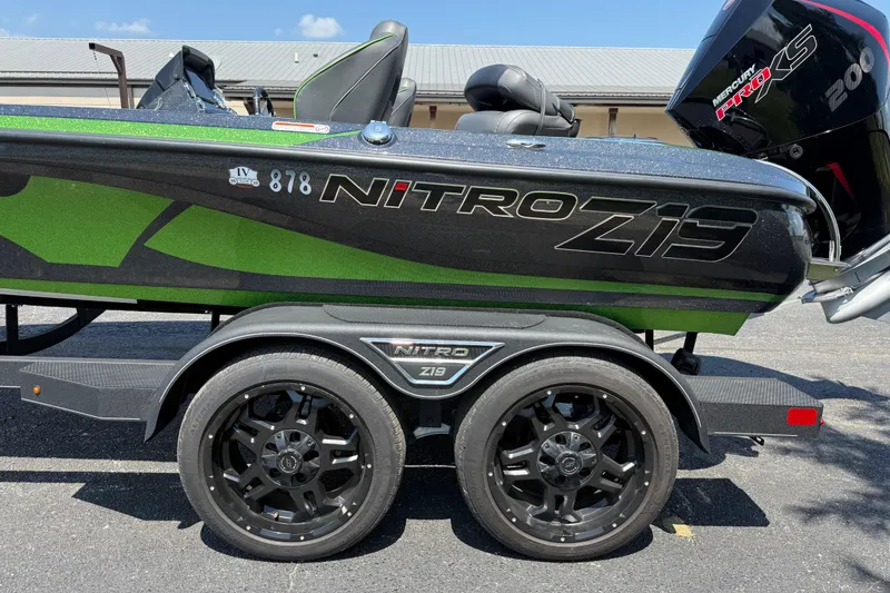 Slide: The Image of 2023 Nitro Z19 boat with green accents and Mercury Pro XS engine on trailer. - 14