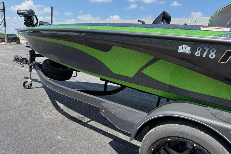 Slide: The Image of 2023 Nitro Z19 boat with green and black design on a trailer. - 15
