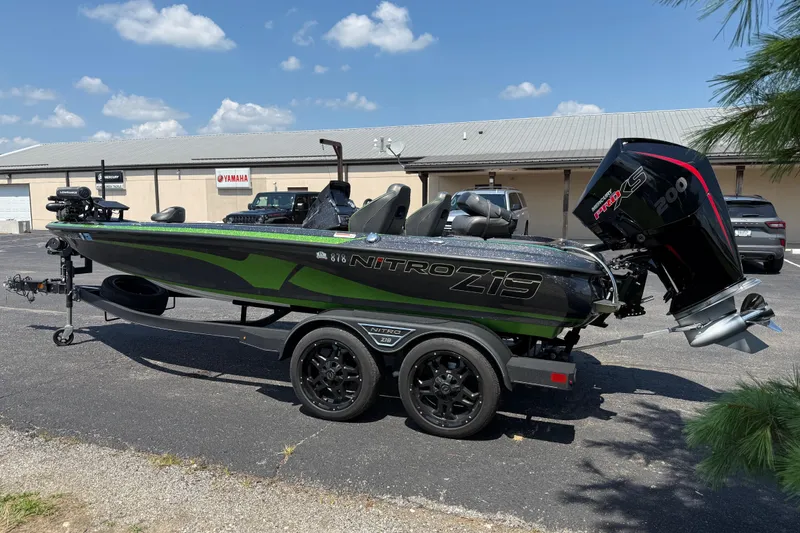 Slide: The Image of 2023 Nitro Z19 boat with trailer, parked outdoors under a clear blue sky. - 5