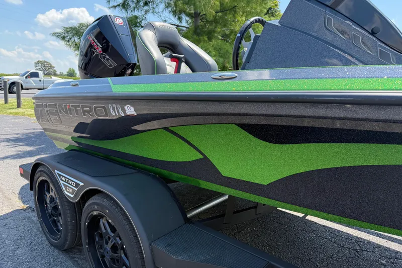 Slide: The Image of 2023 Nitro Z19 boat with green and black design on a trailer. - 9