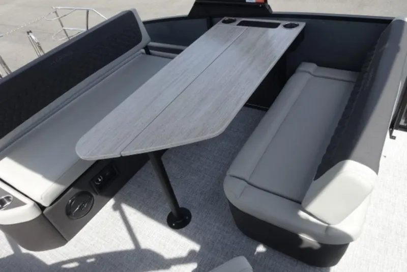 Slide: The Image of 2026 Harris Sunliner 250 boat interior with sleek seating and modern table design. - 11