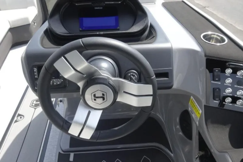 Slide: The Image of 2026 Harris Sunliner 250 boat dashboard with steering wheel and control panel. - 13