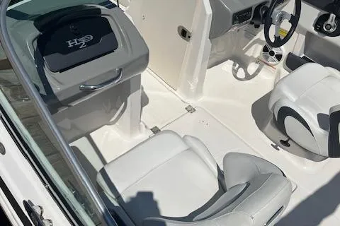 Slide: The Image of 2015 Chaparral 21 H2O Sport boat interior with white seating and steering wheel. - 6