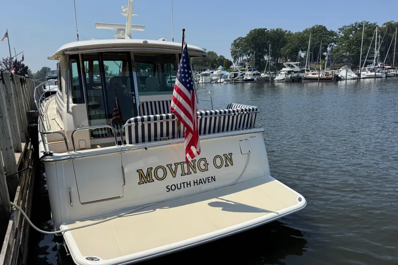 Slide: The Image of 2022 Sabre 48 Salon Express yacht docked, displaying "MOVING ON" and American flag. - 11