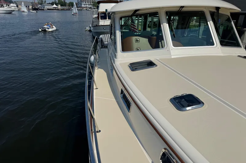 Slide: The Image of 2022 Sabre 48 Salon Express yacht docked in a marina, with scenic waterfront views. - 12