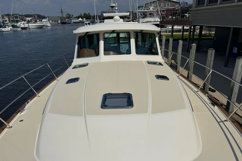 Slide: The Image of 2022 Sabre 48 Salon Express yacht docked at marina, showcasing sleek deck design. - 13