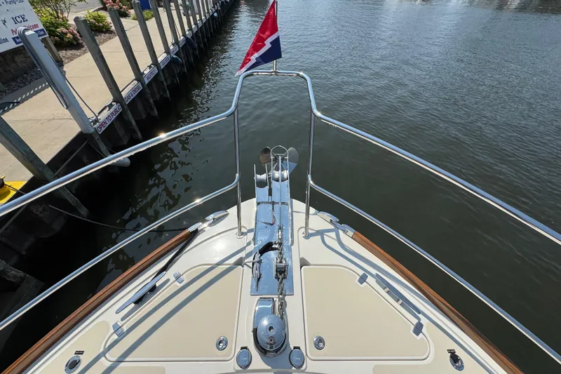 Slide: The Image of Bow view of 2022 Sabre 48 Salon Express yacht docked by a pier. - 14