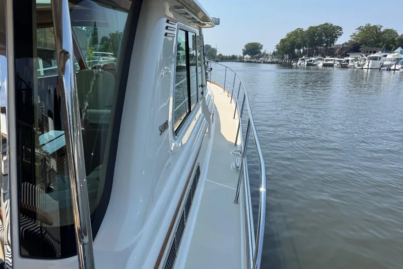 Slide: The Image of 2022 Sabre 48 Salon Express yacht on a calm river, showcasing sleek design and luxury. - 17