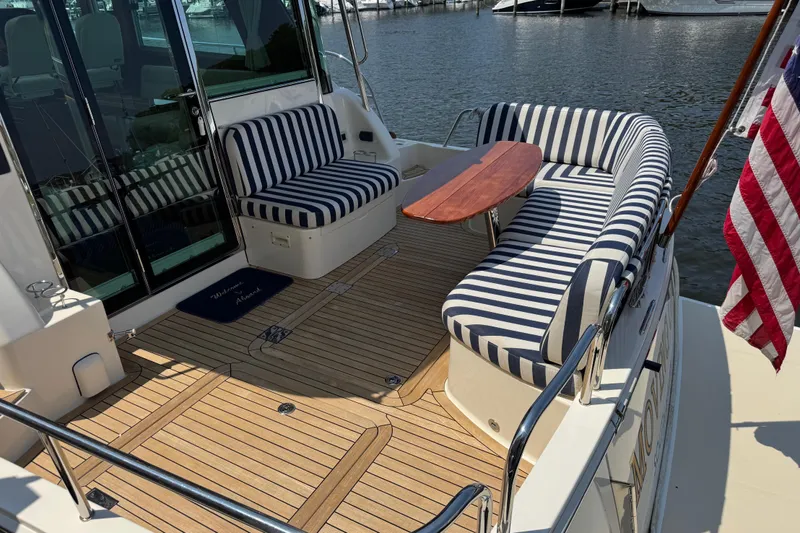Slide: The Image of 2022 Sabre 48 Salon Express yacht with striped seating and wooden deck. - 19