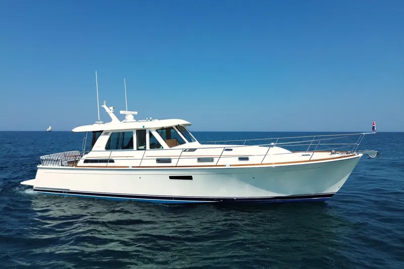 Slide: The Image of 2022 Sabre 48 Salon Express yacht cruising on open sea under clear blue sky. - 2