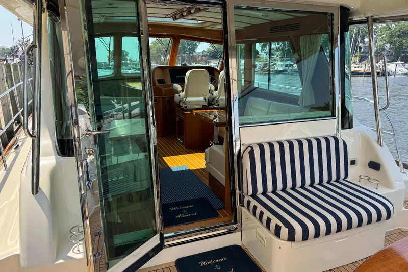 Slide: The Image of 2022 Sabre 48 Salon Express yacht interior with striped seating and open glass doors. - 23