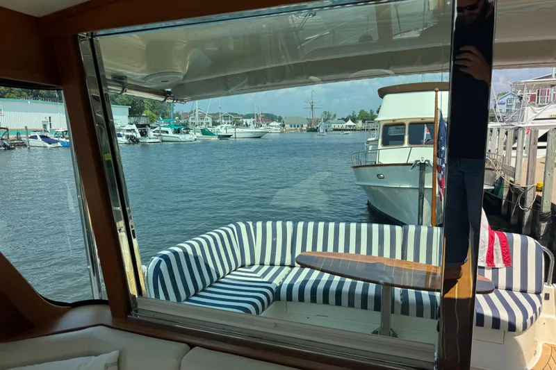 Slide: The Image of Interior view of 2022 Sabre 48 Salon Express yacht with striped seating and marina backdrop. - 26