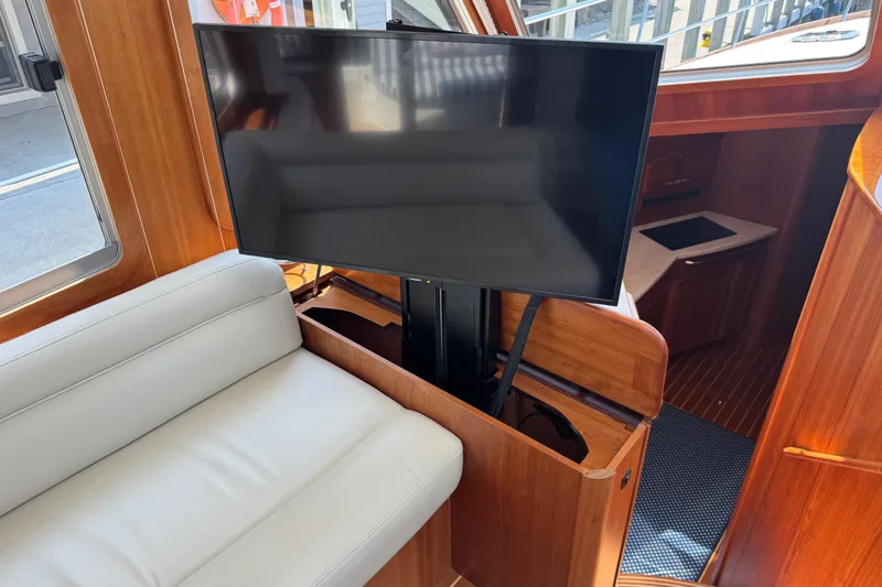 Slide: The Image of 2022 Sabre 48 Salon Express interior with TV and white leather seating. - 32