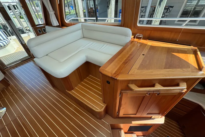 Slide: The Image of Interior of 2022 Sabre 48 Salon Express with white seating and wooden cabinetry. - 33