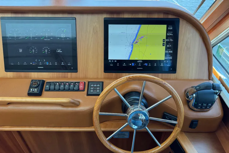 Slide: The Image of Helm of 2022 Sabre 48 Salon Express with navigation screens and controls. - 38