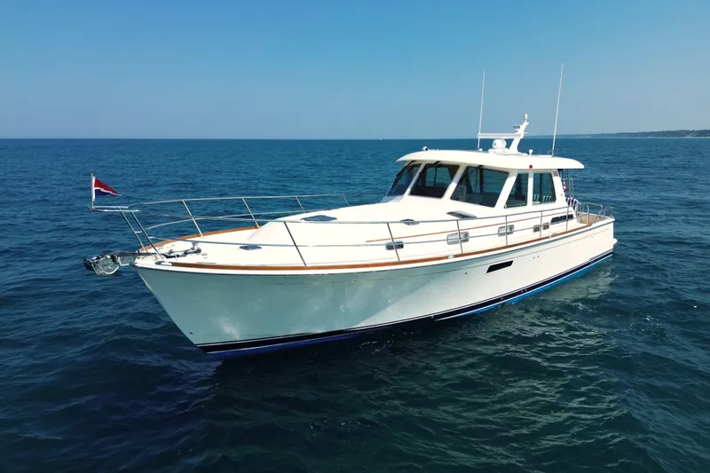 Slide: The Image of 2022 Sabre 48 Salon Express yacht cruising on open sea under clear blue sky. - 4