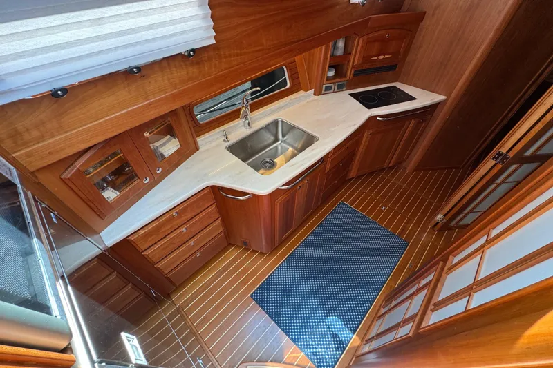 Slide: The Image of 2022 Sabre 48 Salon Express kitchen with wood cabinetry, sink, and stovetop. - 40