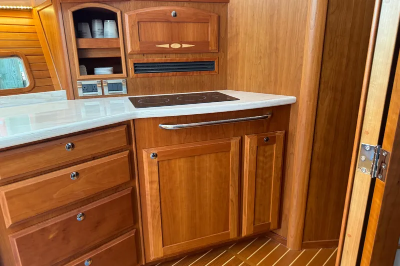 Slide: The Image of 2022 Sabre 48 Salon Express kitchen with wooden cabinetry and modern appliances. - 45
