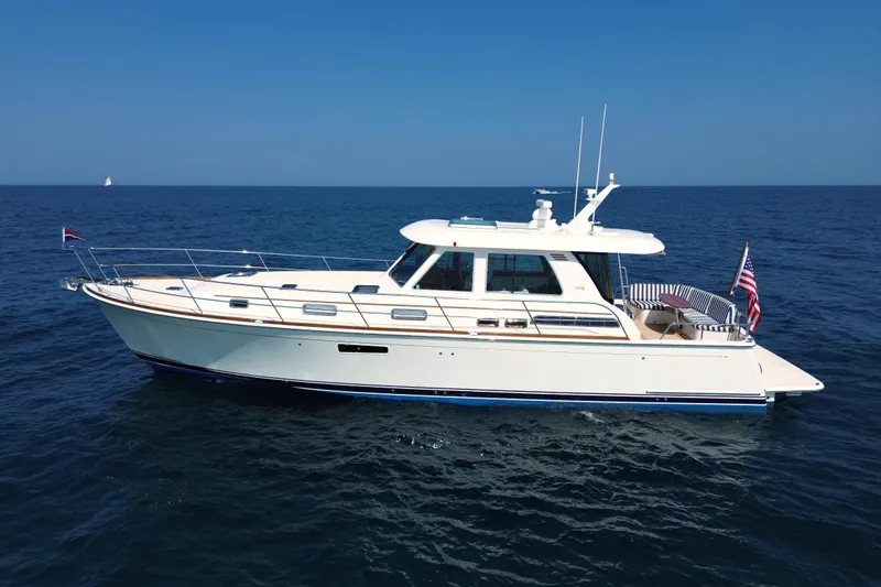 Slide: The Image of 2022 Sabre 48 Salon Express yacht cruising on open sea under clear blue sky. - 5