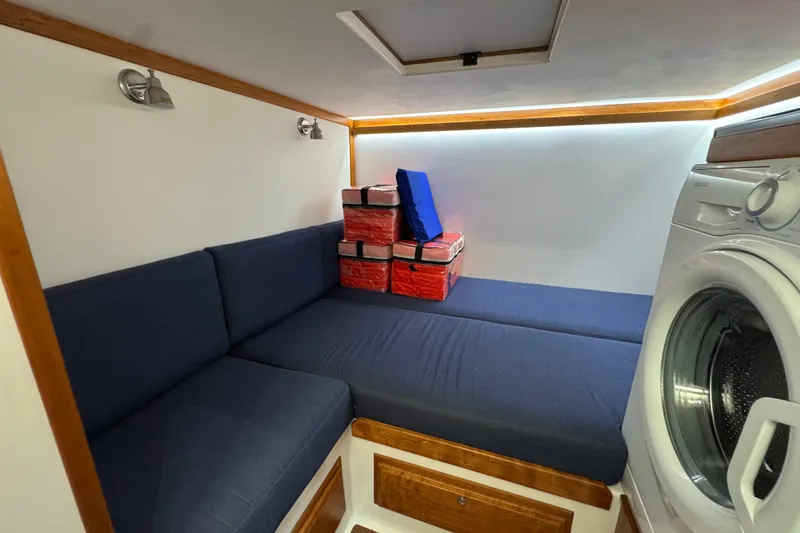 Slide: The Image of Interior of 2022 Sabre 48 Salon Express with blue seating and washing machine. - 63