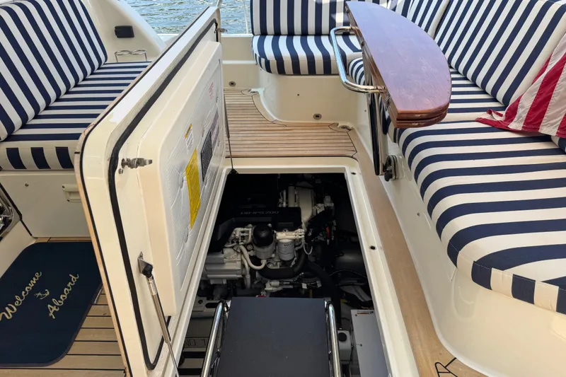 Slide: The Image of 2022 Sabre 48 Salon Express yacht interior with striped seating and open engine compartment. - 67