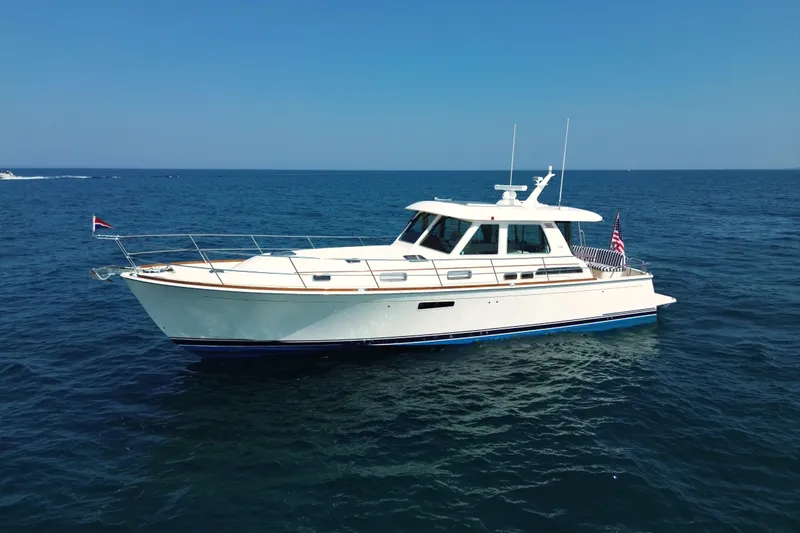 Slide: The Image of 2022 Sabre 48 Salon Express yacht cruising on open sea under clear blue sky. - 7