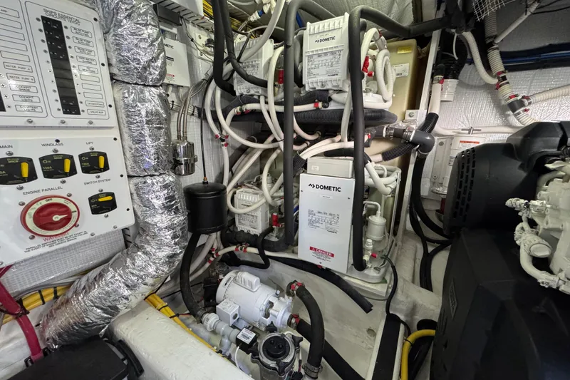 Slide: The Image of Engine room of 2022 Sabre 48 Salon Express with complex wiring and control panels. - 73