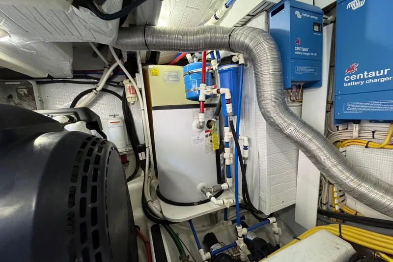 Slide: The Image of Engine room of 2022 Sabre 48 Salon Express with battery chargers and piping. - 75