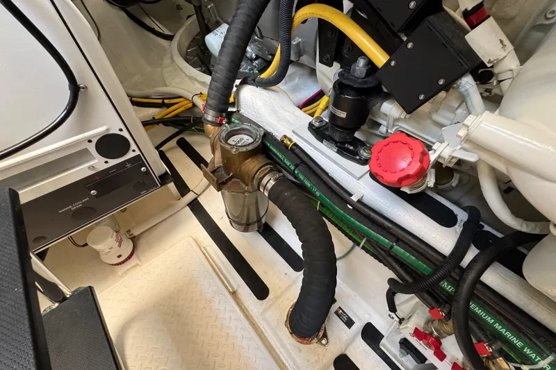 Slide: The Image of Engine room of 2022 Sabre 48 Salon Express, showcasing mechanical components and hoses. - 76