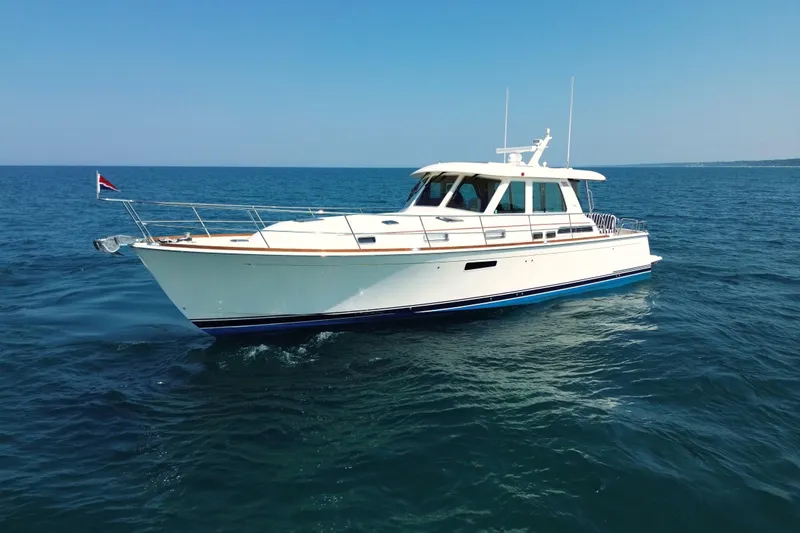 Slide: The Image of 2022 Sabre 48 Salon Express yacht cruising on open sea under clear blue sky. - 8