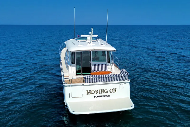 Slide: The Image of 2022 Sabre 48 Salon Express yacht named "Moving On" on open sea. - 9