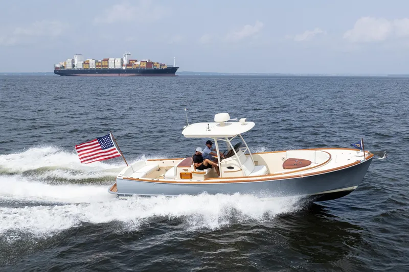 Slide: The Image of 2017 Hinckley Talaria 29C cruising with American flag, container ship in background. - 10